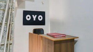 A reception desk with a sign that reads "OYO" on the wall. - Hotel S Grand  (Prayagraj)