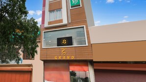 A hotel named 'Grand' with a modern facade, a prominent logo, and a large window. - Hotel S Grand  (Prayagraj)