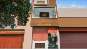 A hotel with a modern facade, a prominent logo, and a sign indicating it is a grand hotel. - Hotel S Grand  (Prayagraj)