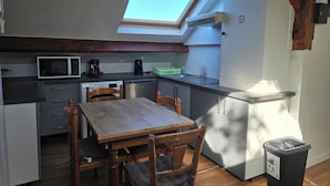 Una cocina compacta con tragaluz, microondas, lavavajillas y un cubo de basura.