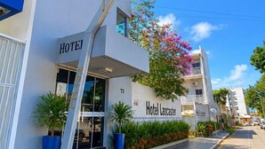 Entrada de hotel con letrero, placa y el número 73 en el edificio.