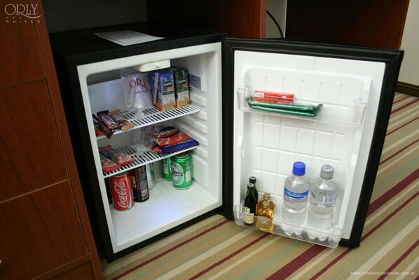 A mini-fridge stocked with snacks, beverages, and condiments. - Orly Hotel (Corrientes)