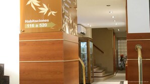 Een hotelingang met een bord waarop de kamer nummers 116 tot en met 520 staan.