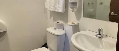 A modern bathroom with a toilet, sink, and a towel rack.