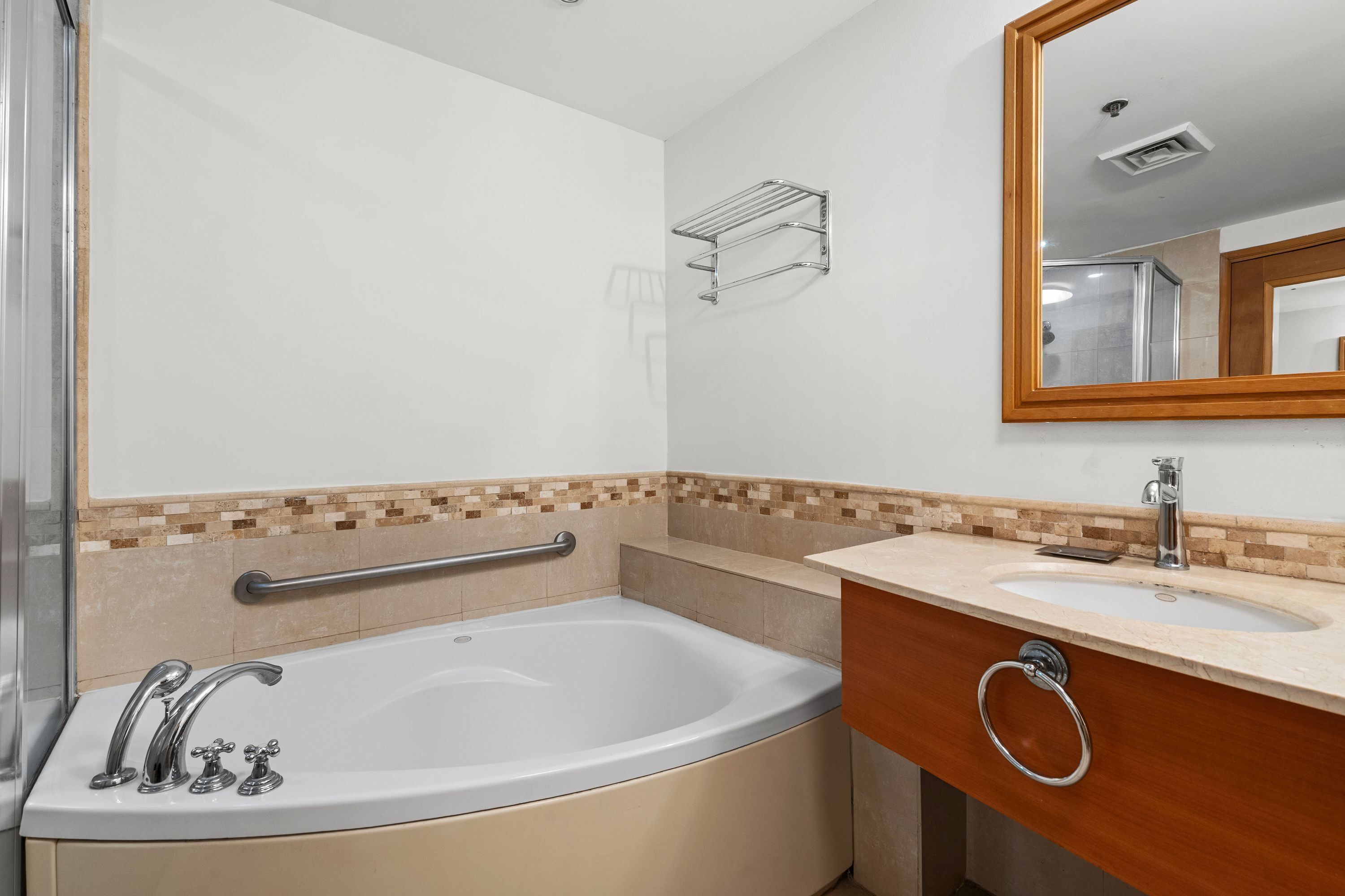 Un baño moderno con una bañera independiente, un tocador con lavabo y un espejo.