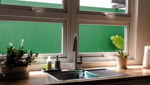 Une cuisine avec une fenêtre, un évier et des placards.