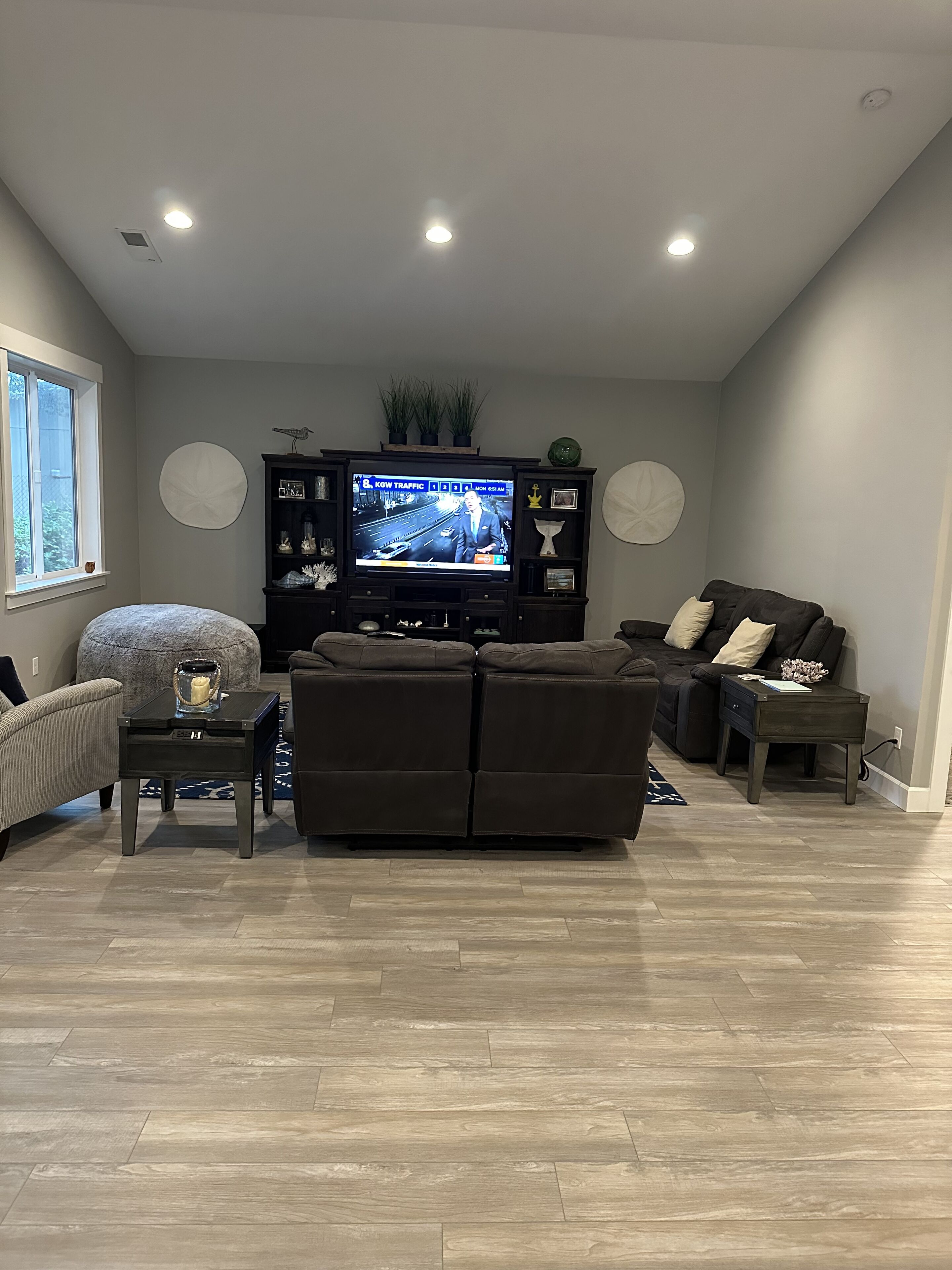 A modern living room with a sectional sofa, a television, and a small table.