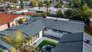 A residential area with a house featuring a flat roof, a covered patio with outdoor furniture, and a small garden. - Sunny Retreat Beaches Lakes Trails (La Mesa)