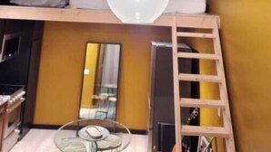 A loft-style room with a hanging light fixture, a bunk bed, a ladder, and a small table with a glass top. - Sunny Loft Beaches Lakes Trails (La Mesa)