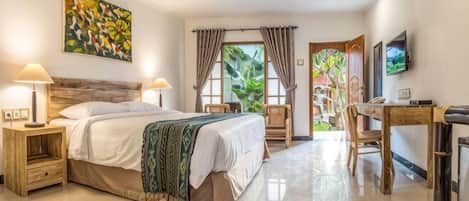 A hotel room with a bed, bedside tables, a desk, a chair, a television, and a window with curtains.