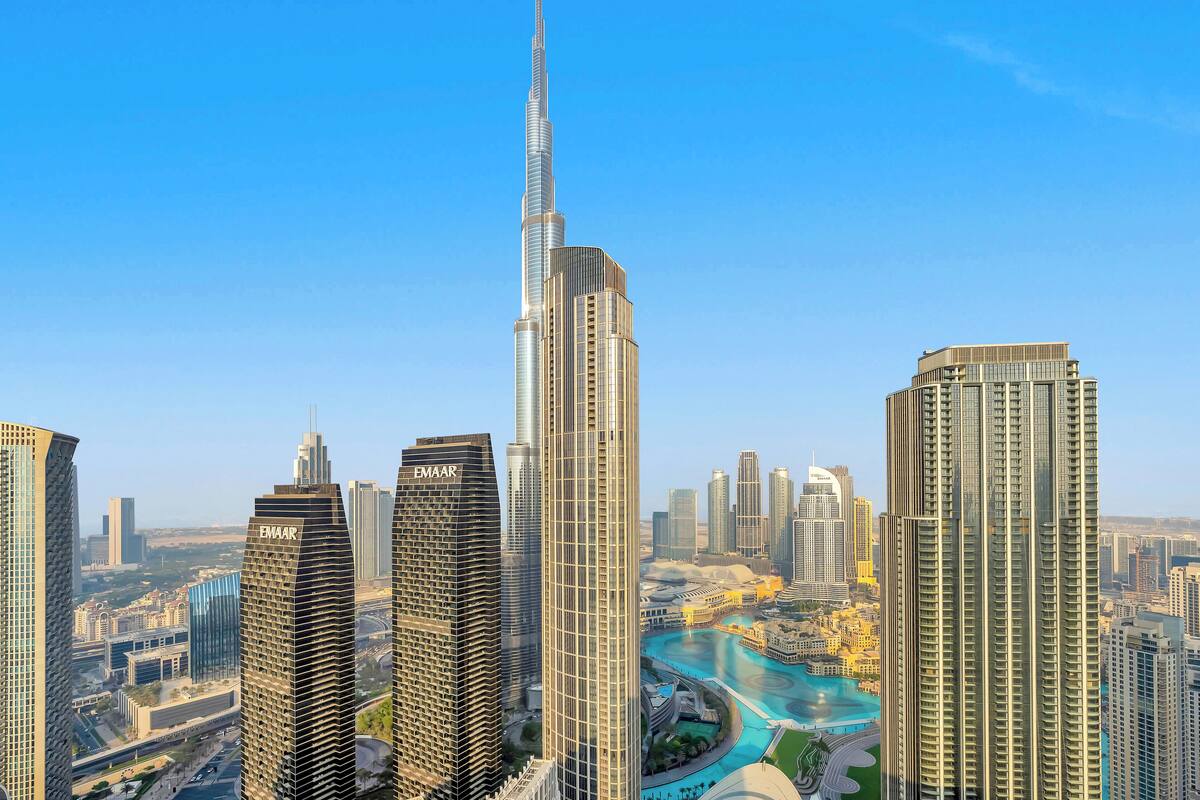 Un paysage urbain avec de nombreux immeubles de grande hauteur, dont une tour imposante surmontée d’une flèche.