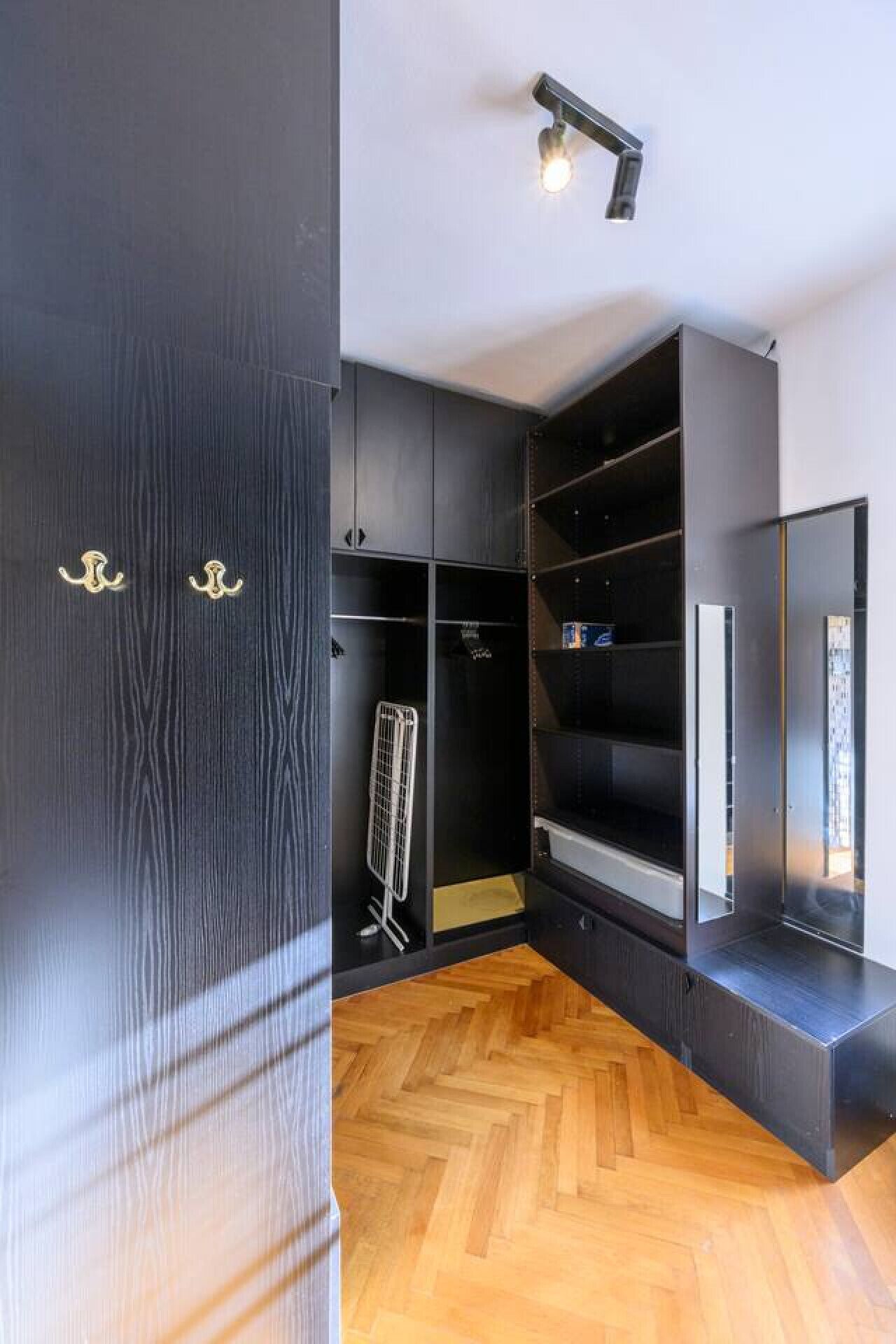 A modern room with built-in wardrobes, a radiator, and a mirror.