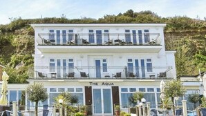 A two-story building with balconies and a sign reading "The Aqua". - Osbourne at the Aqua (Shanklin)