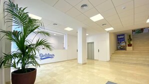 Un hall d’entrée spacieux avec un comptoir d’accueil portant l’inscription « Rentalmar ».
