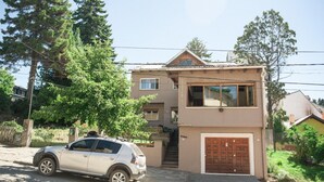 A two-story house with a car parked in front. - Phoenix Hostel (San Carlos de Bariloche)