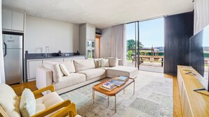 A modern living room with a sofa, coffee table, and a view of the outdoors. - Solar La Luna (Sao Pedro)