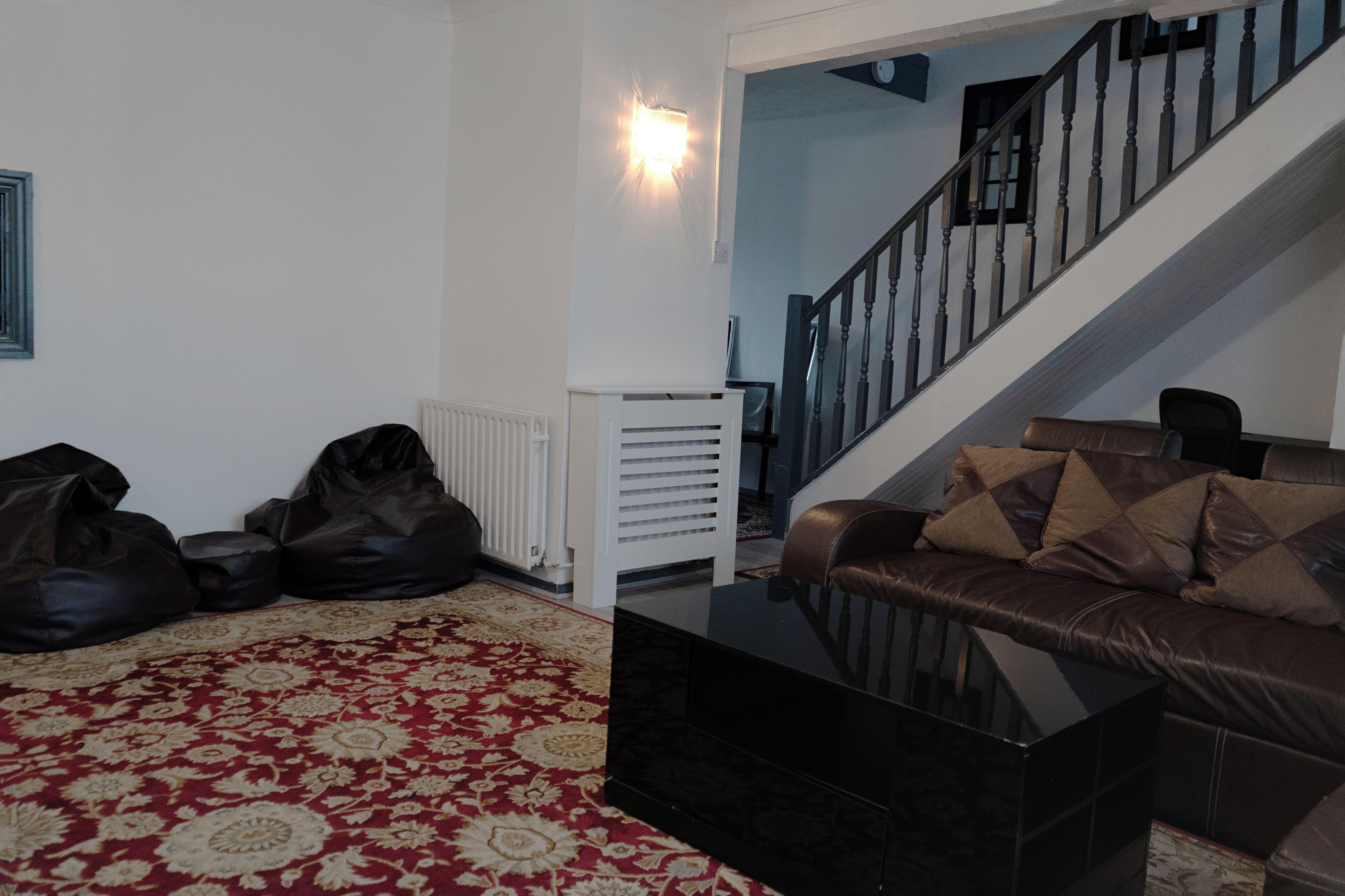 Ein Wohnzimmer mit einer Couch, einem Couchtisch und einer Treppe.