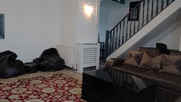 Ein Wohnzimmer mit einer Couch, einem Couchtisch und einer Treppe.