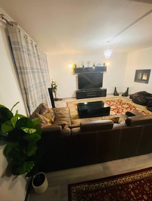 A living room with a sofa, a TV, and a patterned rug. - Surrey Hills Retreat - 2 Bed - Easy Access to Central London (Ash)