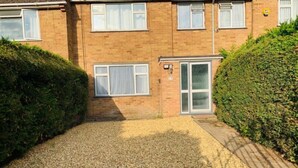 A two-story brick house with a gravel driveway, a small front garden, and a conservatory. - Surrey Hills Retreat - 2 Bed - Easy Access to Central London (Ash)