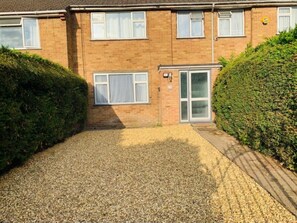 A two-story brick house with a gravel driveway, a small front garden, and a conservatory. - Surrey Hills Retreat - 2 Bed - Easy Access to Central London (Ash)