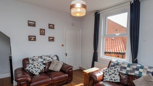 A furnished living room with two leather sofas, a wooden coffee table, and a ceiling light fixture. - Harbour View (Whitby)