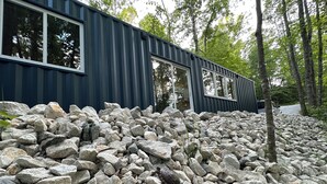 A modern building with large windows and a stone foundation.