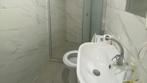 Ein Badezimmer mit Dusche, Toilette und Waschbecken.
