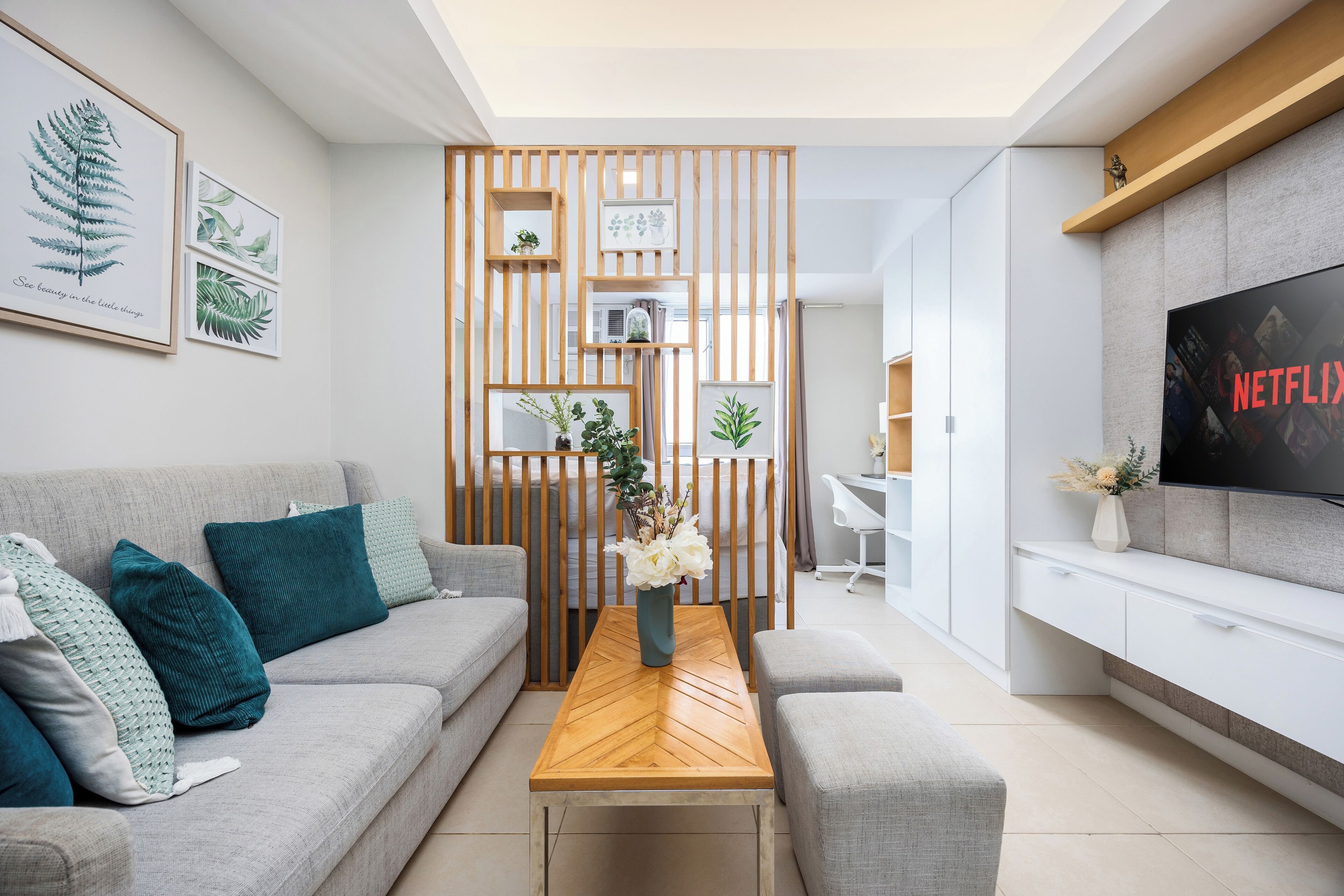 A modern living room with a sofa, coffee table, and a TV on a stand.