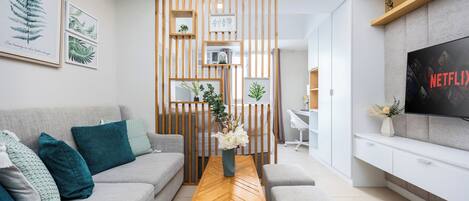 A modern living room with a sofa, coffee table, and a TV on a stand.