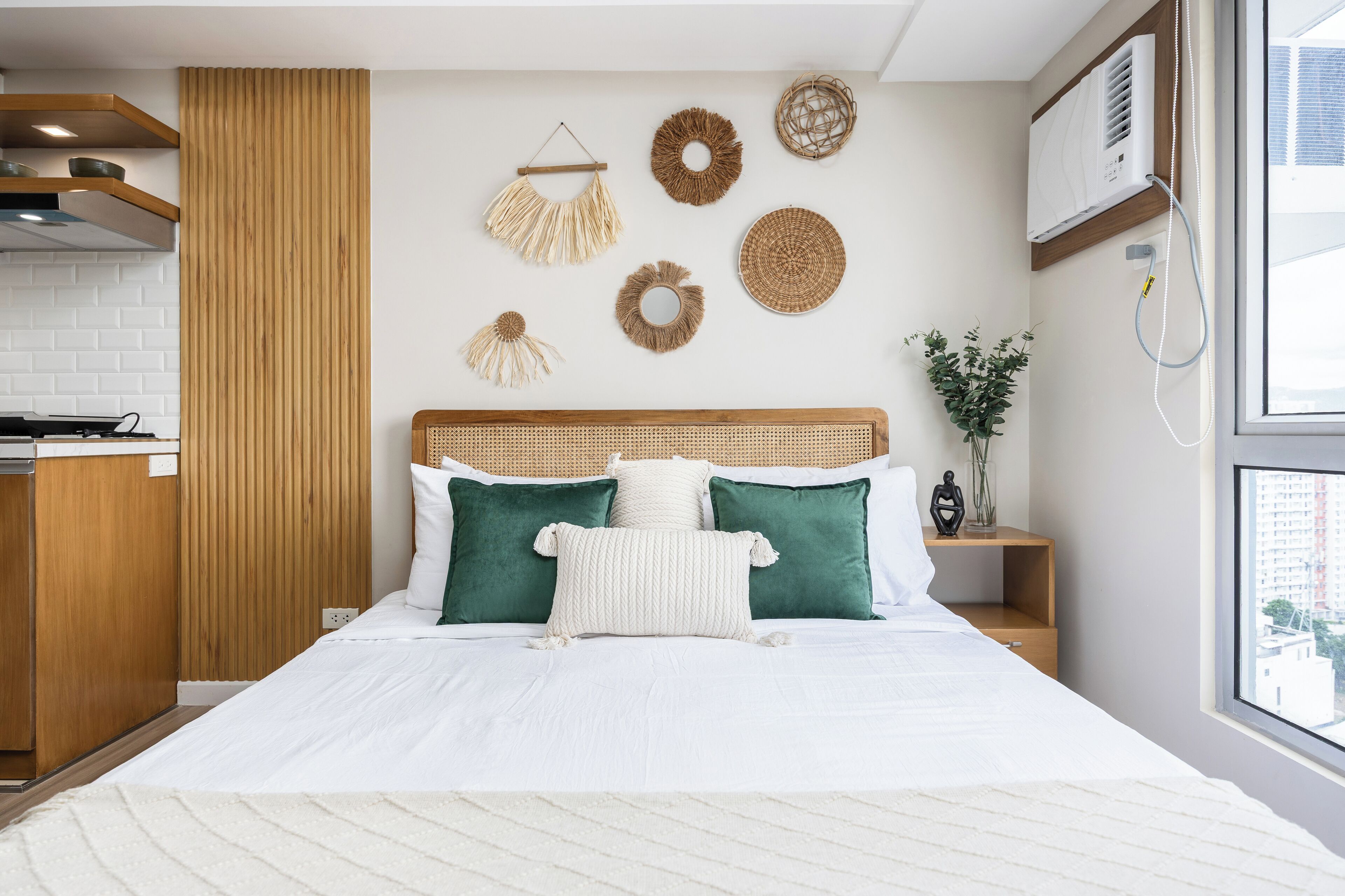 A modern bedroom with a large bed, wooden headboard, and decorative wall hangings.