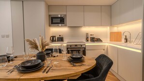 A modern kitchen with a central island, built-in microwave, and stainless steel appliances.