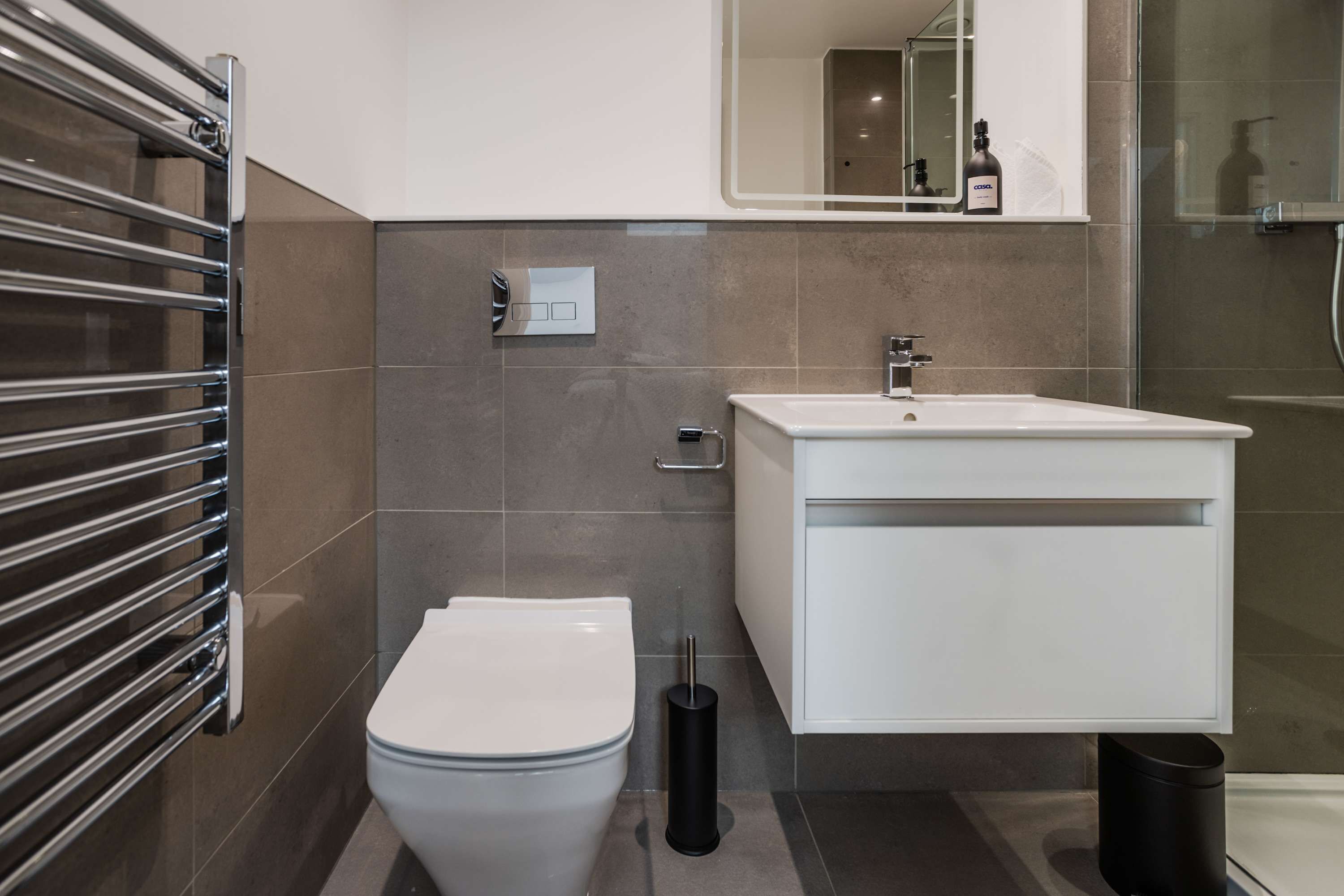 A modern bathroom with a toilet, sink, and shower.
