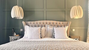 A neatly made bed with a patterned bedspread, a tufted headboard, and several decorative pillows. - Home in Appledore with own parking and Hot Tub. Dogs welcomed (Appledore)