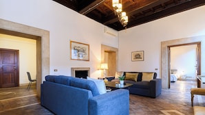 A spacious living room with a fireplace, two sofas, and a coffee table.