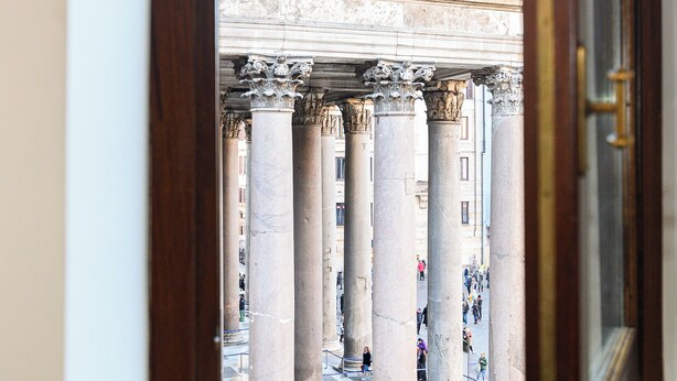 A view through a doorway of a building with large stone columns and a classical architectural style.