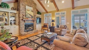 Una sala de estar acogedora con chimenea de piedra, vigas de madera y asientos cómodos.