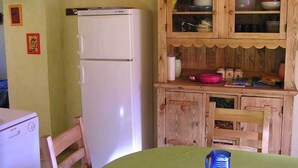 Une cuisine avec un réfrigérateur blanc, des placards en bois et une table verte.