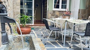 A patio with stone flooring, a water feature, outdoor furniture, and a view of the interior through a glass door. - Cariño BBQ House - Casa Senen (Cariño)