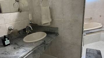 A bathroom with a marble sink, a towel rack, and a bathtub.