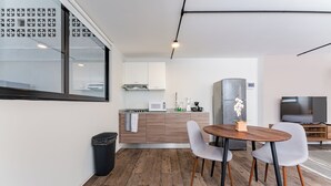 A modern kitchen with a dining area, wooden flooring, and a large window. - VH | Condesa nice loft with roof terrace + GYMNASIUM | 248 (Ciudad de México)