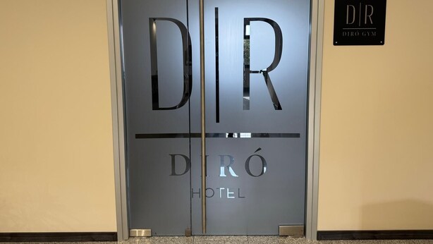 A hotel entrance with a glass door featuring the name 'DIR' and 'HOTEL' in reflective lettering. - Hotel Diró (Avila)