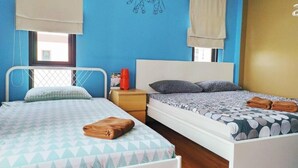 Un dormitorio con dos camas, un cuadro de un elefante y una ventana con cortinas.