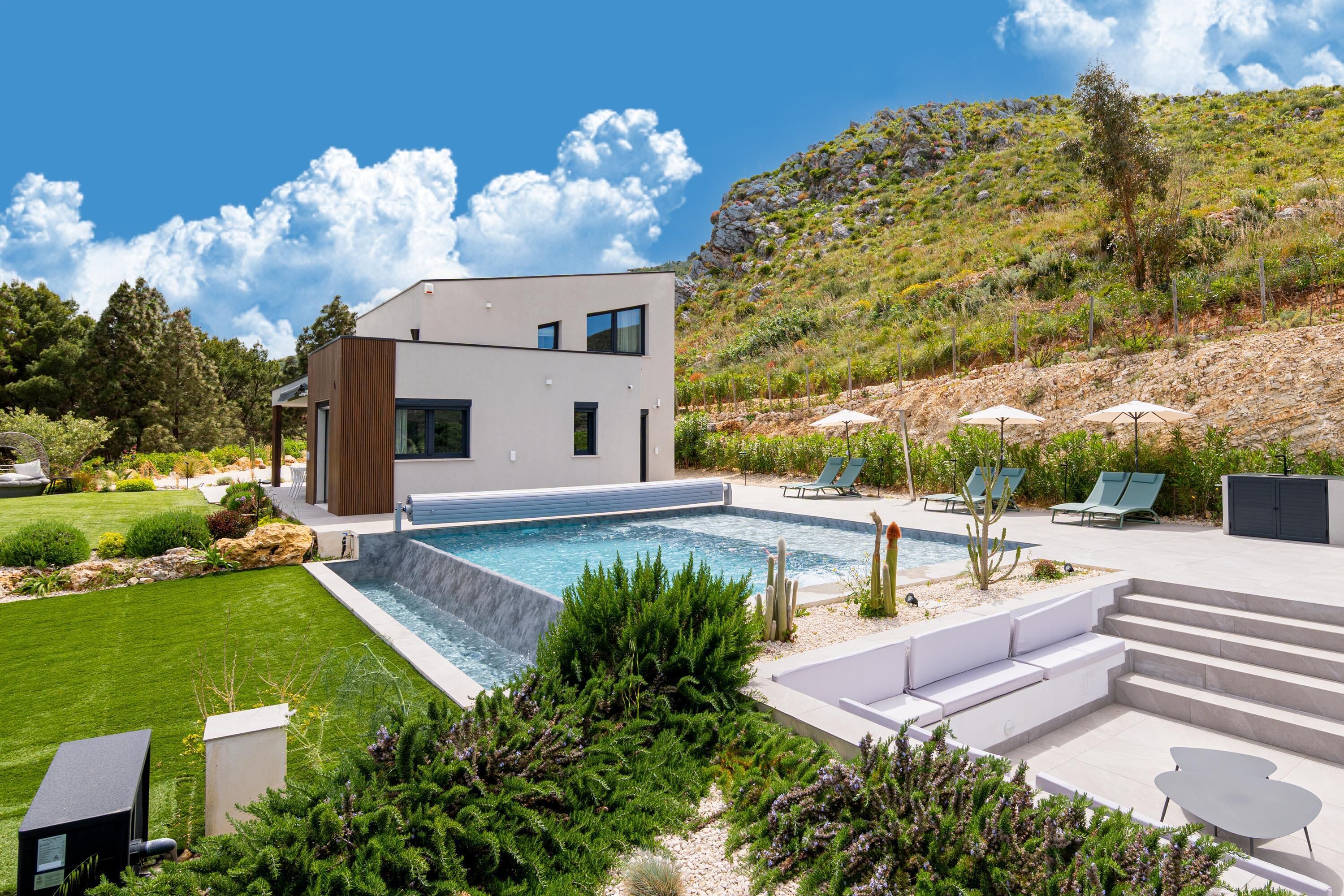 A modern house with a swimming pool, outdoor seating, and a landscaped garden.