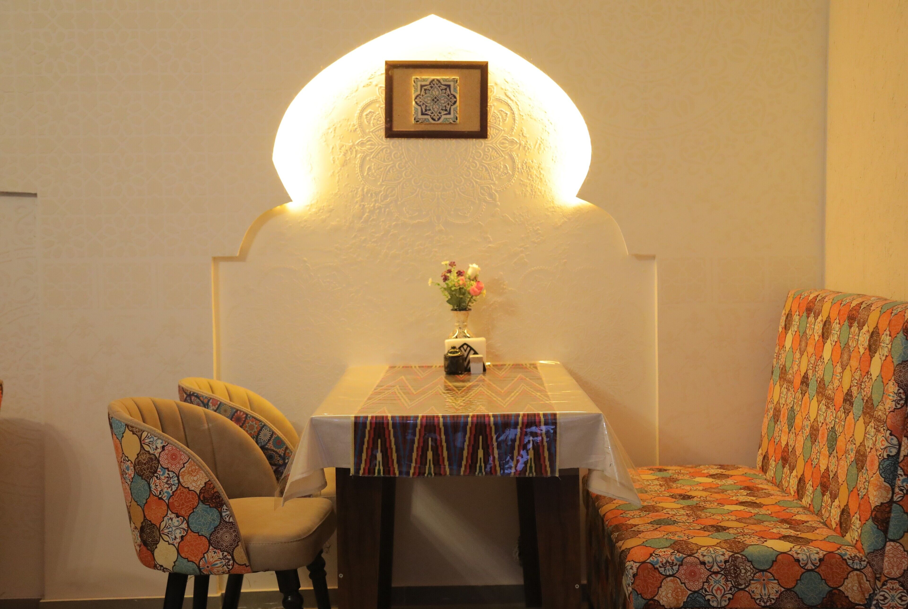 A dining area with a table, chairs, and a decorative wall.