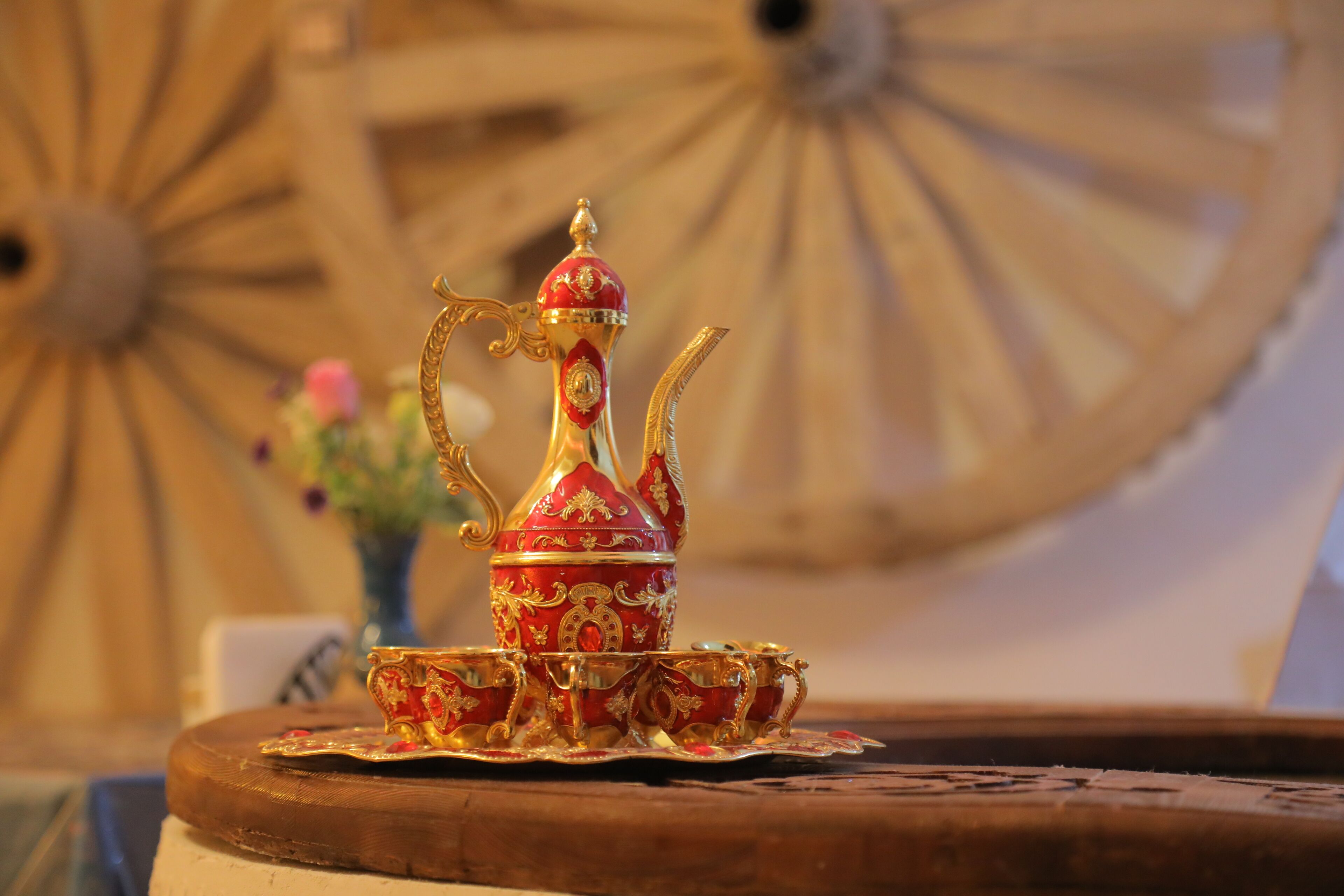 A traditional tea set with a teapot and cups on a wooden tray.