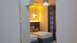 A hotel room with a bed, bedside tables, a hanging light fixture, and a patterned curtain. - Oasis al Khiva Boutique Hotel Inside Citadel (Khiva)