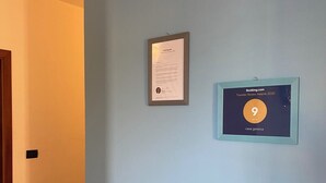 Een gang met een ingelijst certificaat aan de muur.