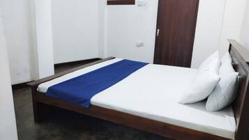 A single bed with a wooden frame and a blue bedspread.