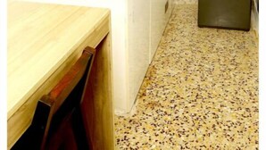 Een kleine keuken met een spoelbak, fornuis en een kleine koelkast.
